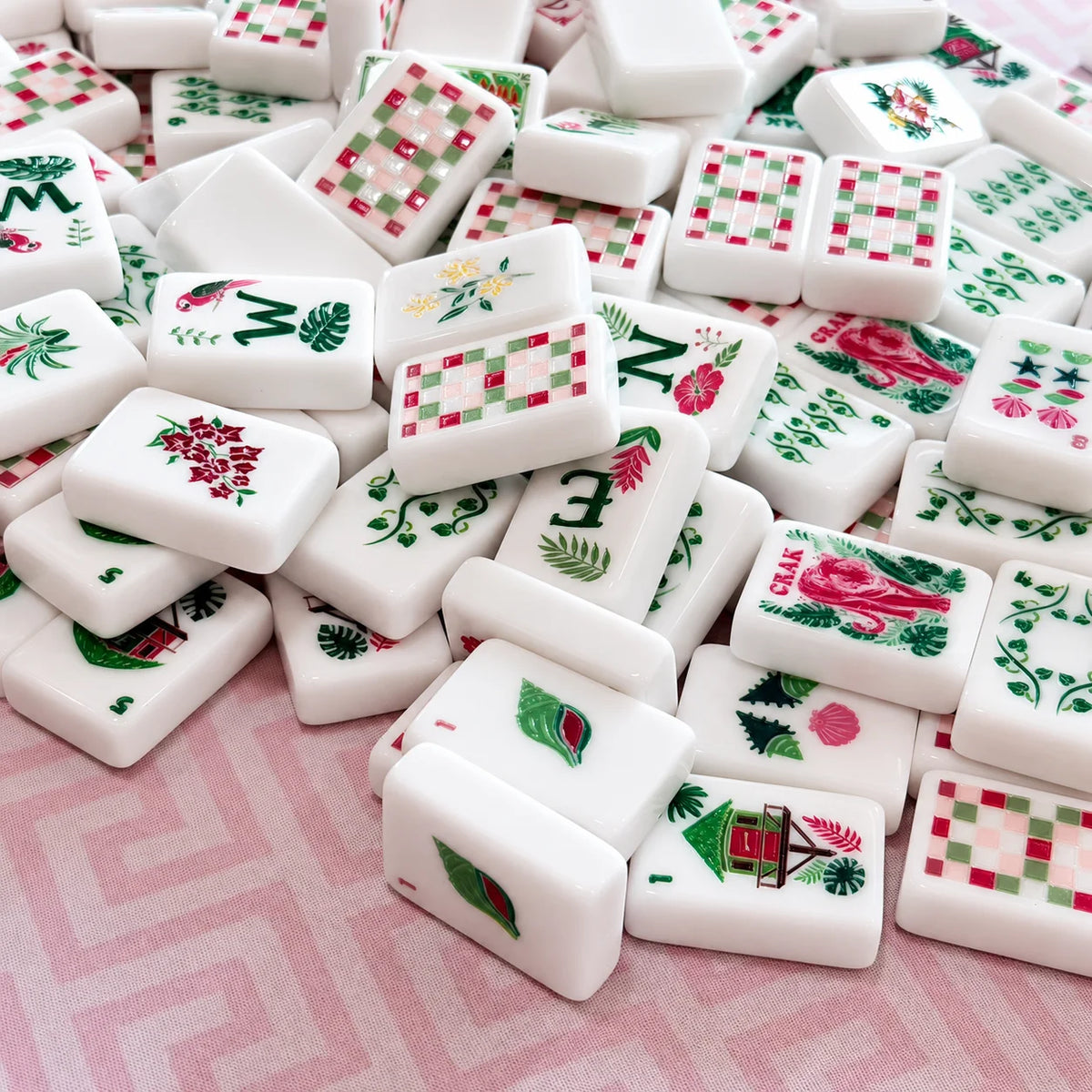 Close-up of Tropical Reverie white Mahjong tiles with floral faces and pink-and-green checkerboard backs